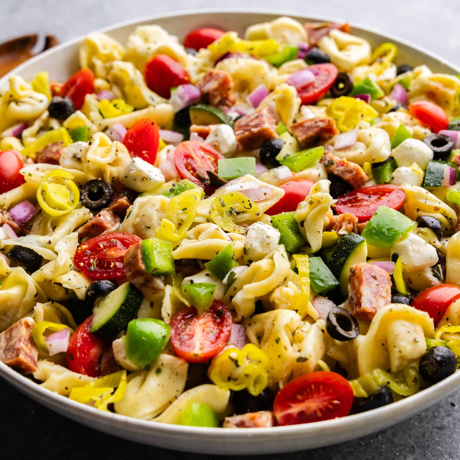 A large serving bowl of tortellini pasta salad.