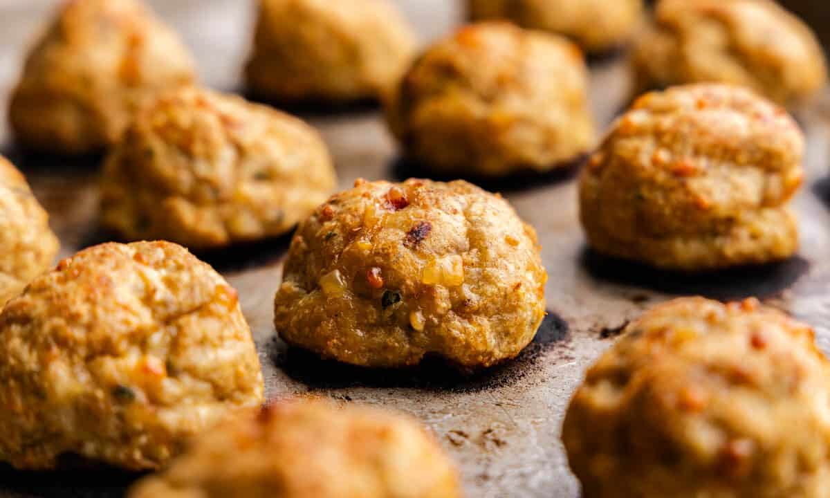 A close up of baked chicken meatballs on a baking sheet.