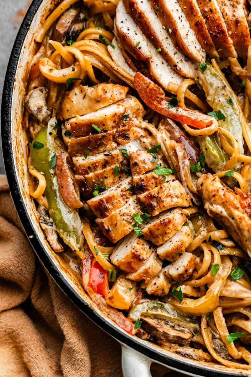 An overhead close up view of a skillet of Cajun chicken pasta.