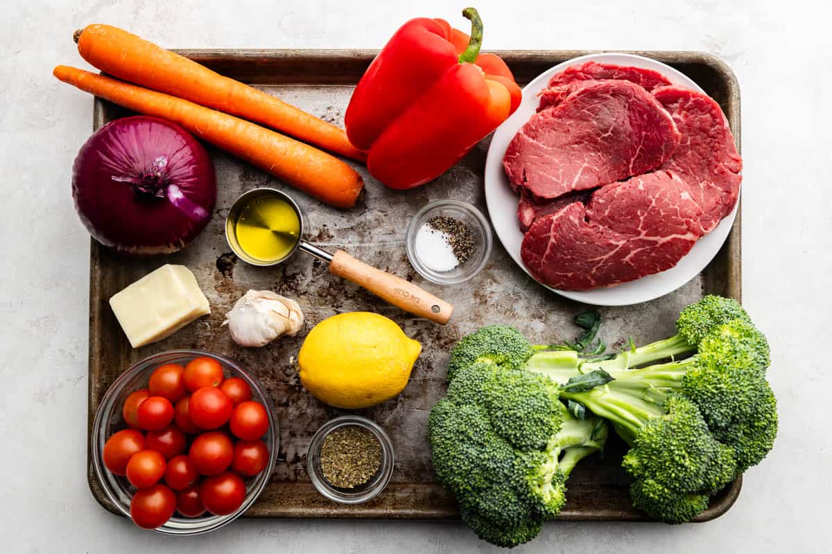 Italian sheet pan An overhead view of ingredients needed to prepare steak and vegetables.