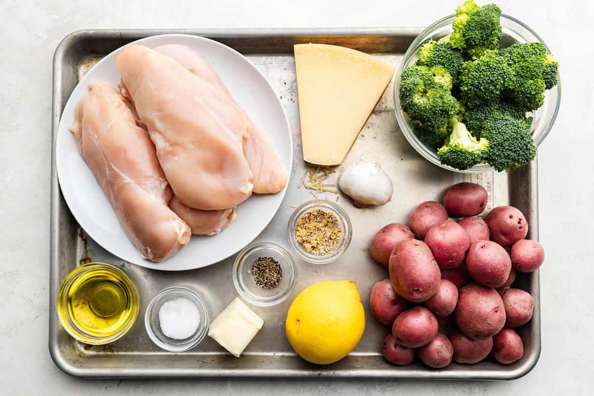 An overhead view of the ingredients needed to make the sheet pan Garlic Parmesan Chicken Potatoes and Broccoli.