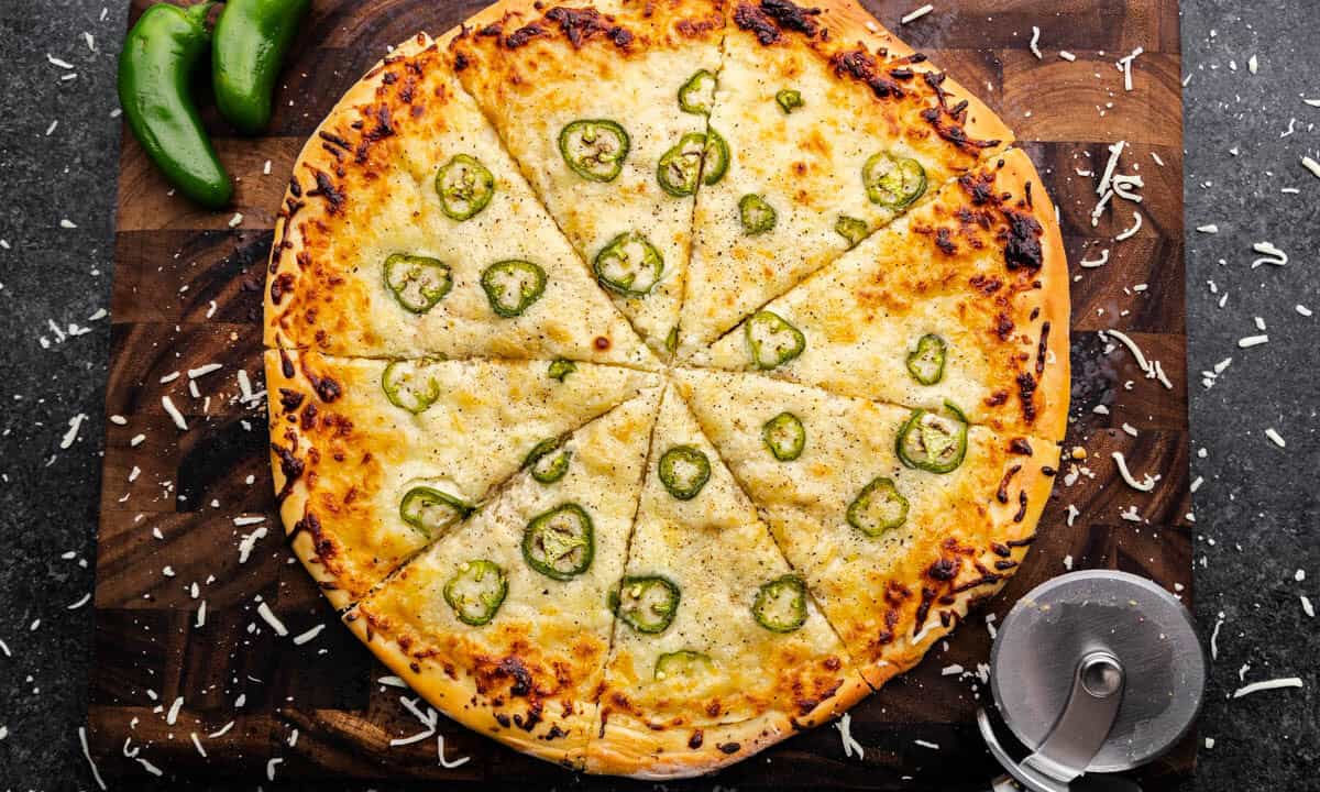 An overhead shot of a full Jalapeno Scalloped Potato Pizza cut into slices.