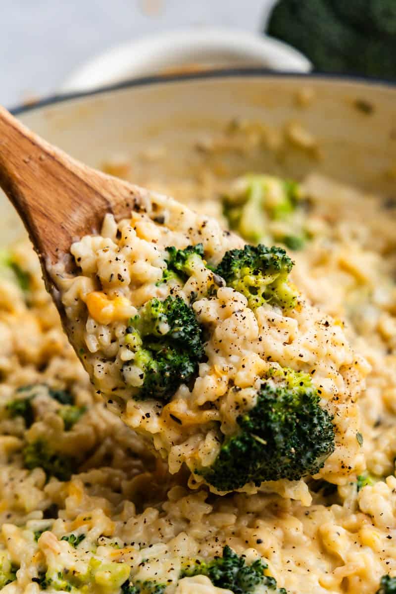 A close-up view of a spoonful of chicken broccoli rice from the pot that was cooked.