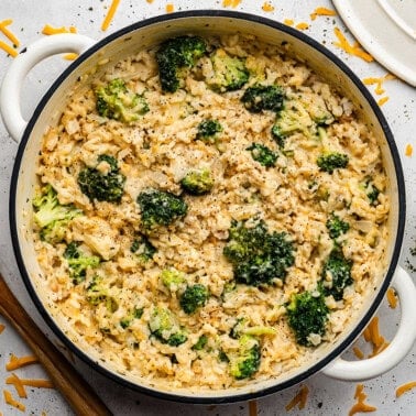 An overhead view of a pot full of rice, chicken, and broccoli.