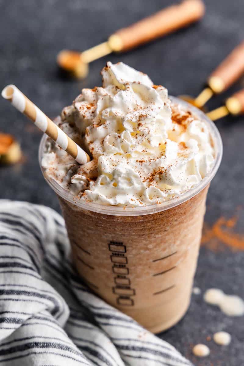 A pumpkin spice frappe topped with whipped cream in a plastic cup.