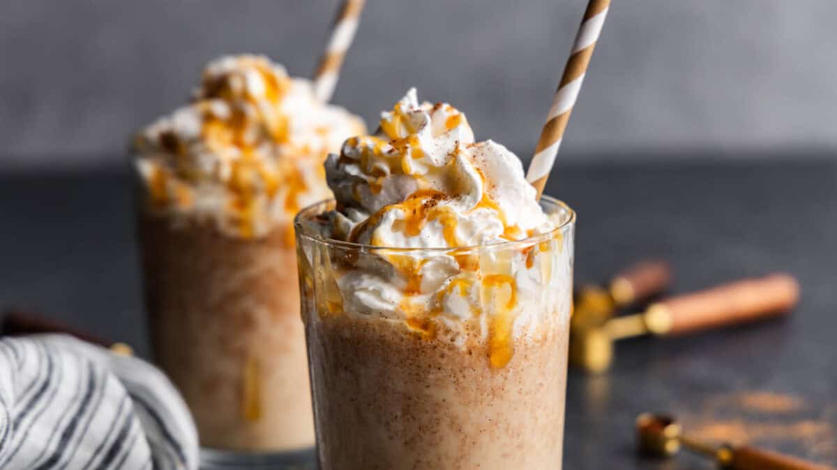 Two pumpkin spice frappes on a table.