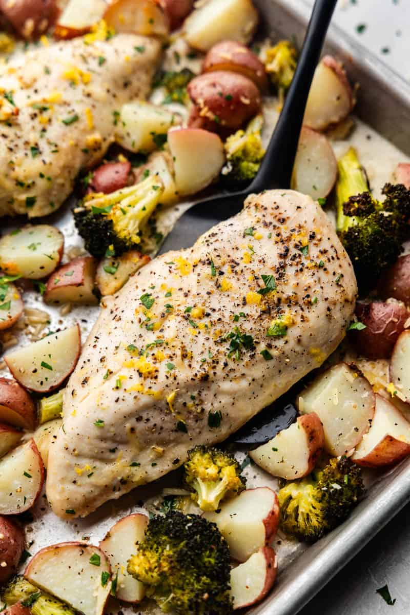 A sheet pan of garlic parmesan chicken and roasted potatoes and broccoli.