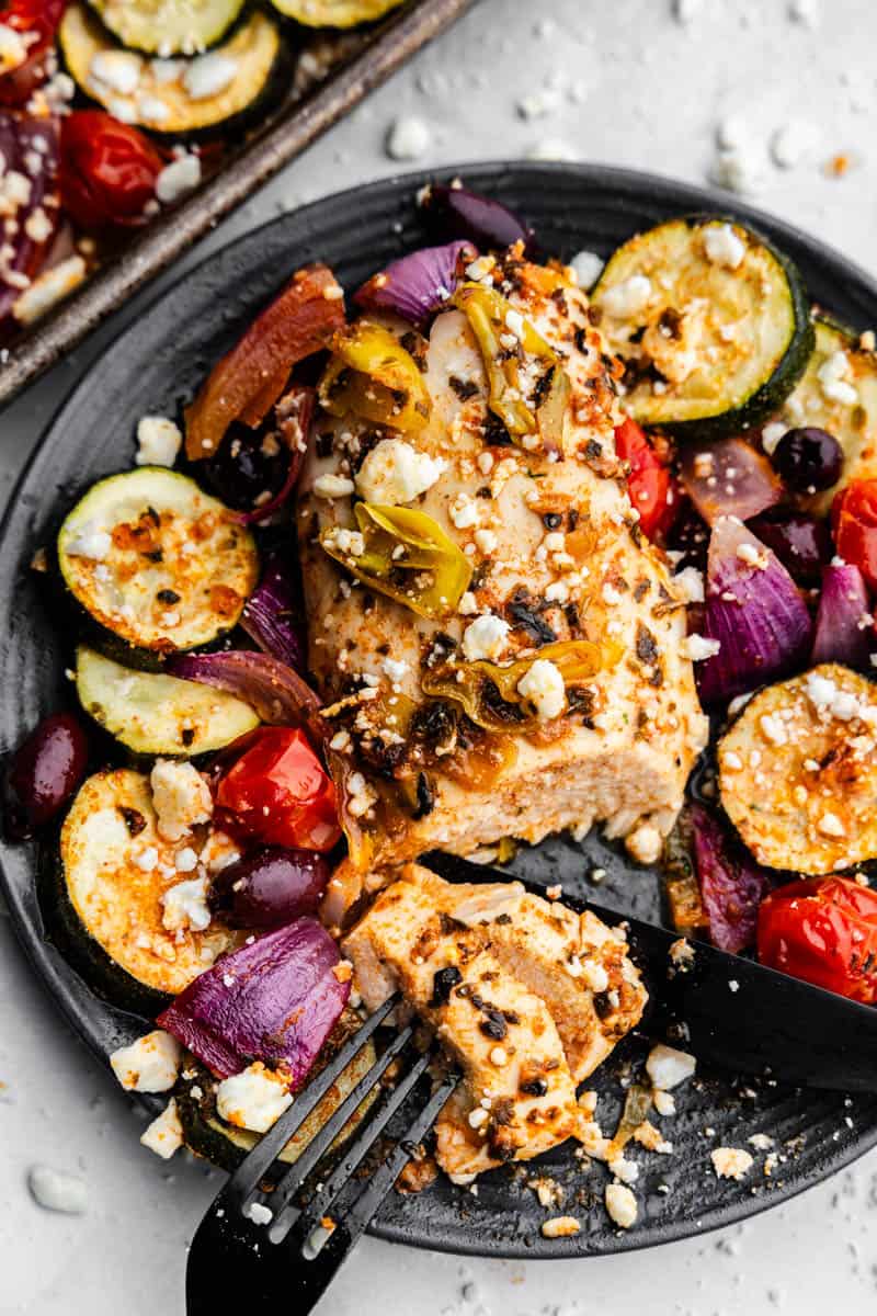 A plate of Greek chicken and roasted vegetables.