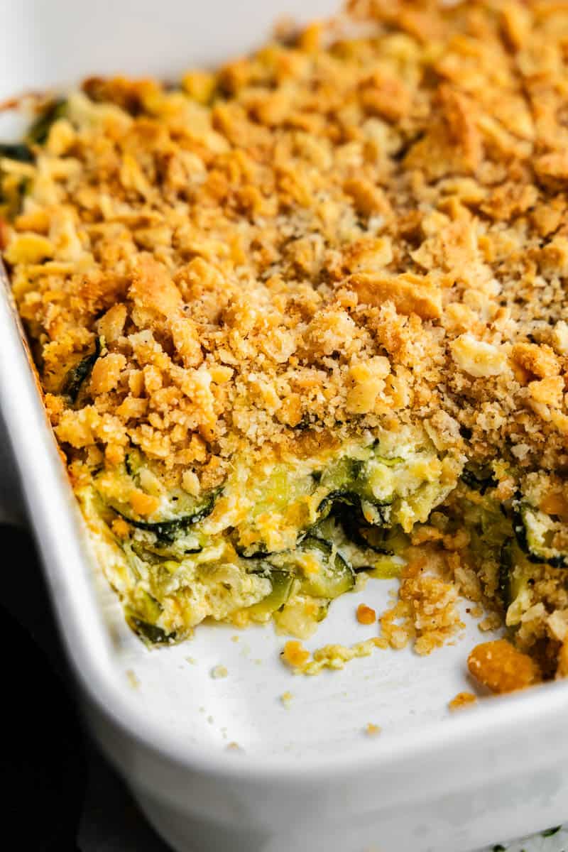 An overhead view of a casserole dish with zucchini casserole, with a corner serving removed.