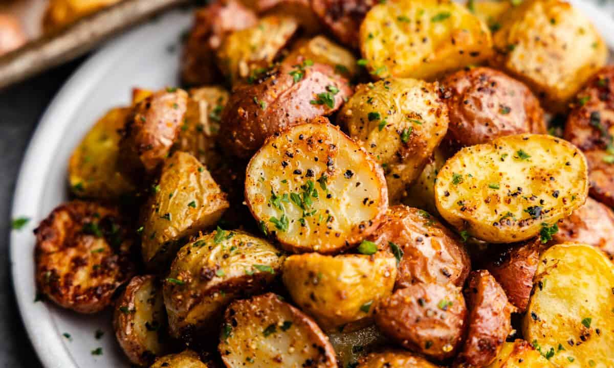 A plate loaded with cut, seasoned and perfectly golden potato chunks.