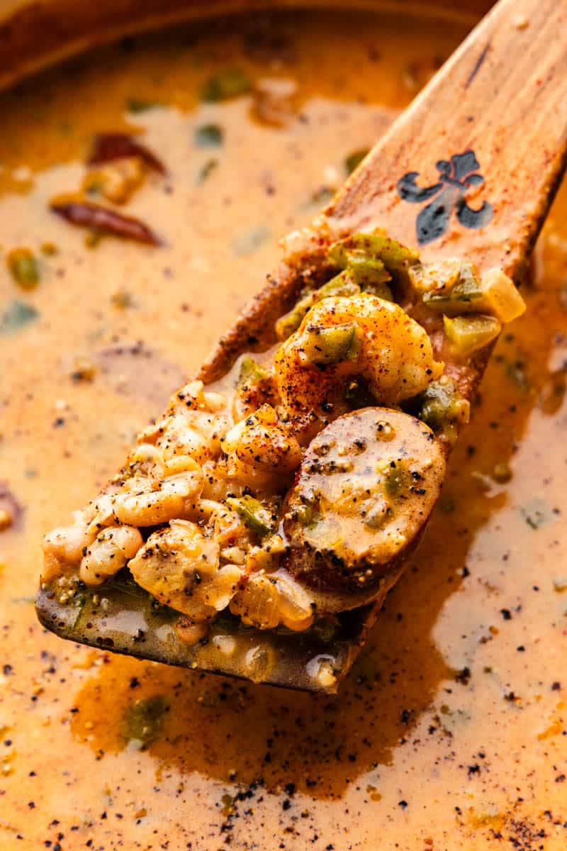 A roux spoon scoops out a serving of Cajun White Chicken Chili from the pot.