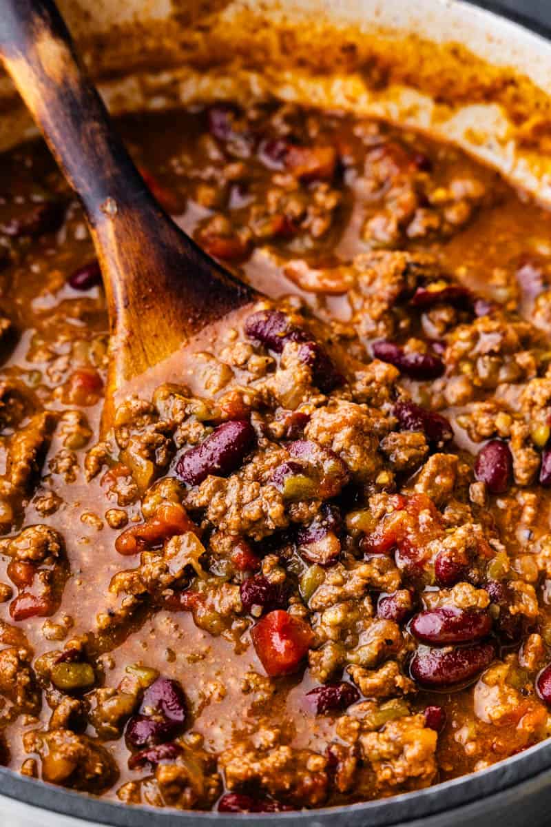 A close up view of a wooden spoon in a pot of no fuss chili.