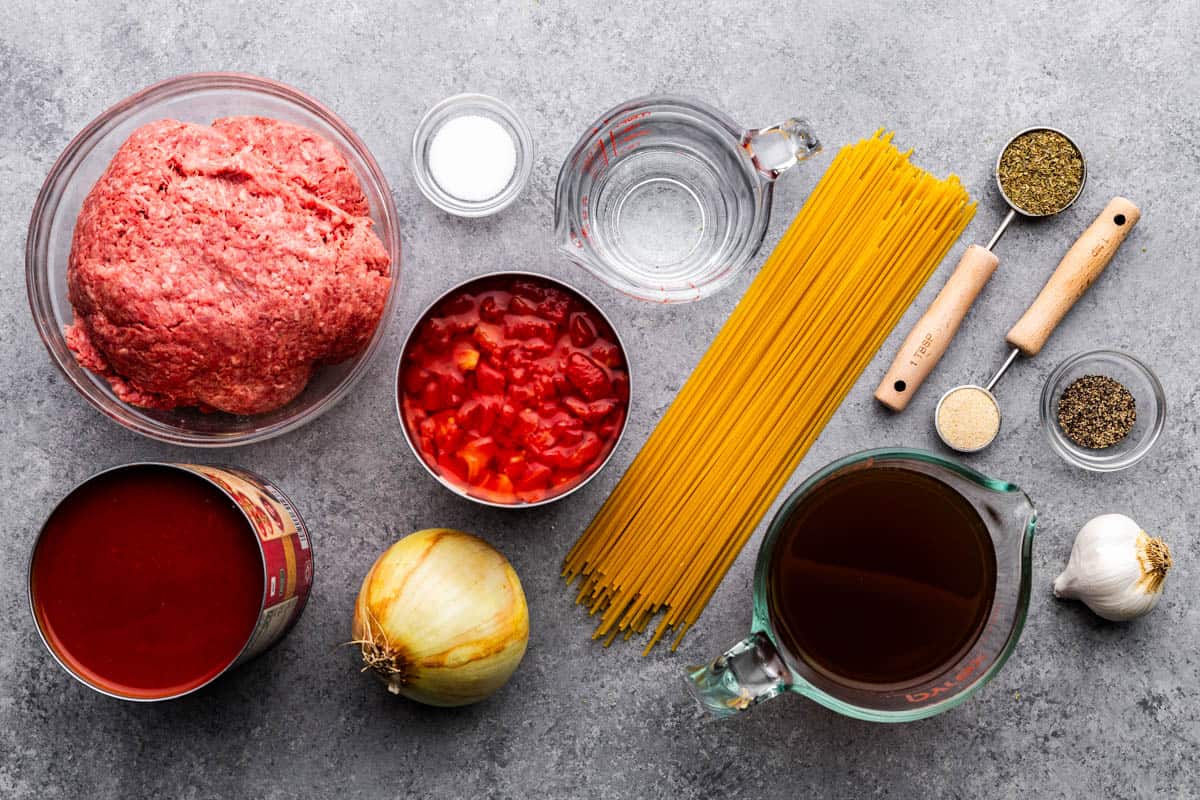 An overhead view of dry, raw and wet ingredients to use for One Pot Spaghetti.