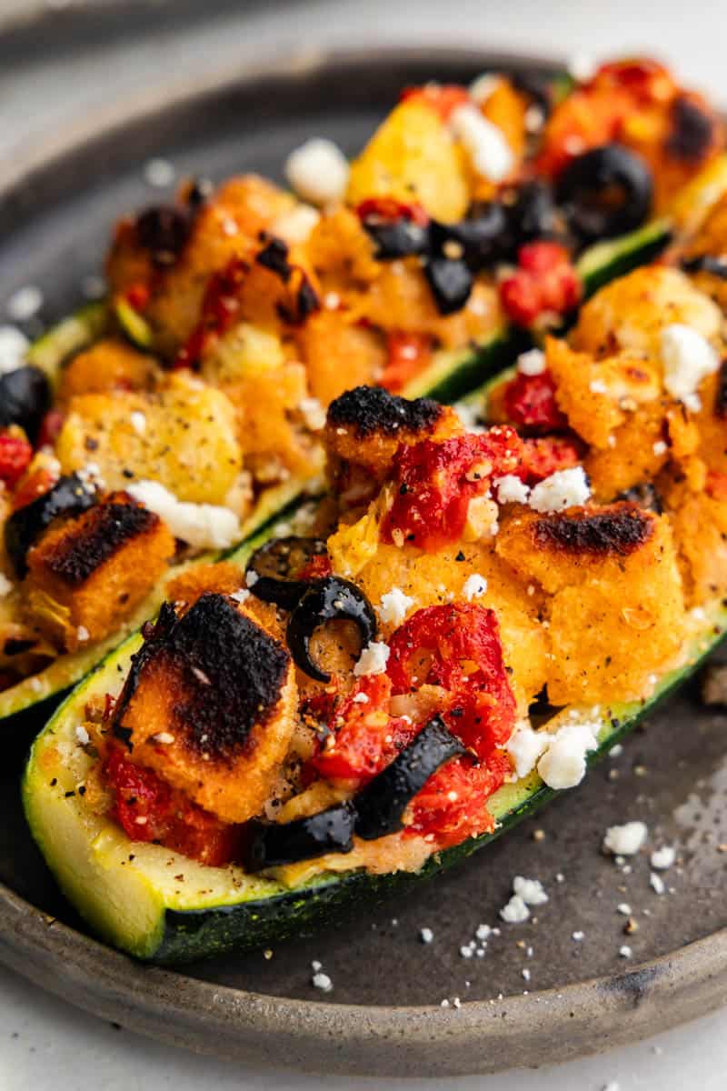 A close up view of a mediterranean style stuffed zucchini boat.