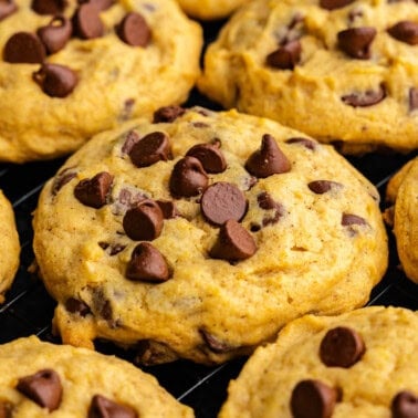 A close up of a grouping of pumpkin chocolate chip cookies.