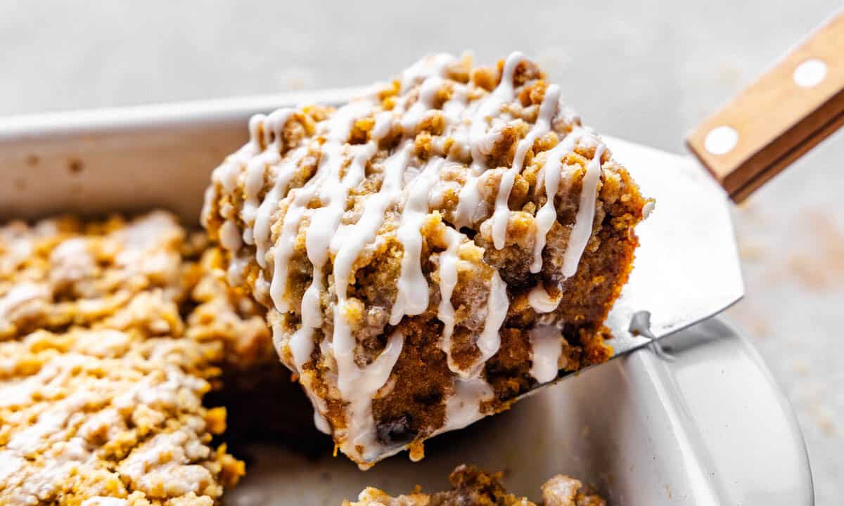 A slice of pumpkin crumb cake being lifted from the pan.