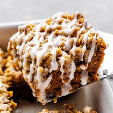 A slice of pumpkin crumb cake being lifted from the pan.