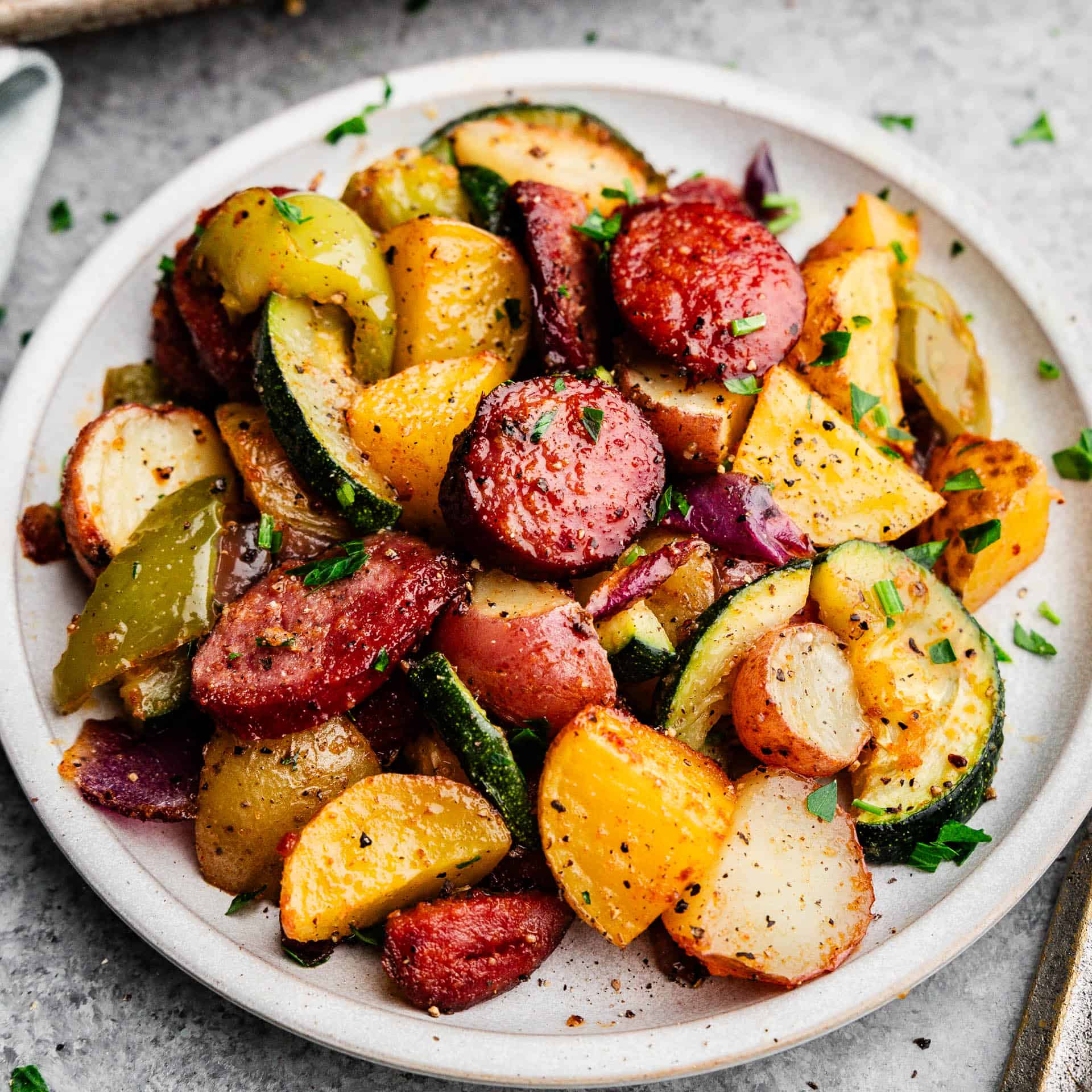 A plate filled with cooked and seasoned sausage and vegetables.