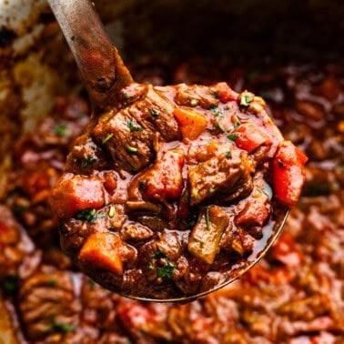 A ladle scooping out a helping of Texas beef chili from the slow cooker.