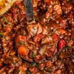 A ladle resting in a slow cooker full of Texas beef chili.