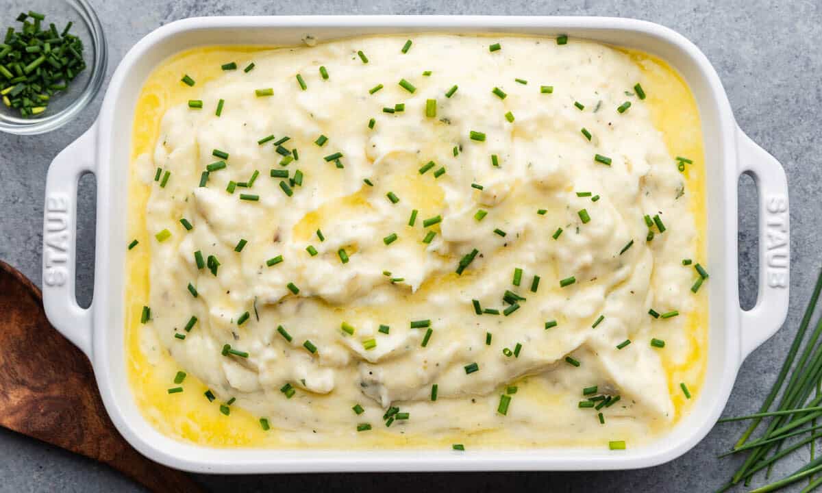 An overhead view of a casserole dish filled with creamy herbed butter mashed potatoes.