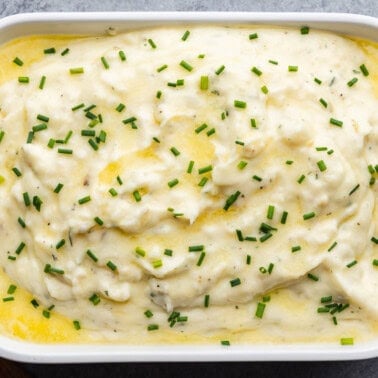 An overhead view of a casserole dish filled with creamy herbed butter mashed potatoes.