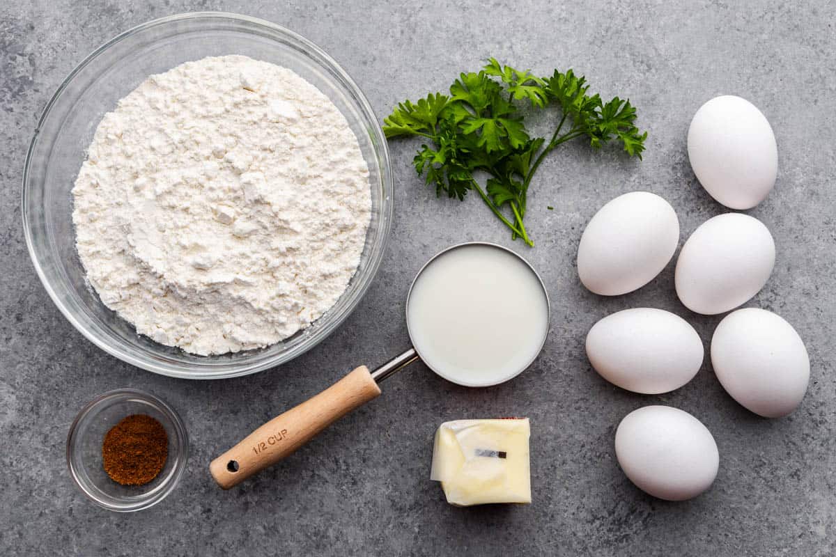 An overhead view of measured ingredients and eggs needed to make Granny's German Spaetzle.