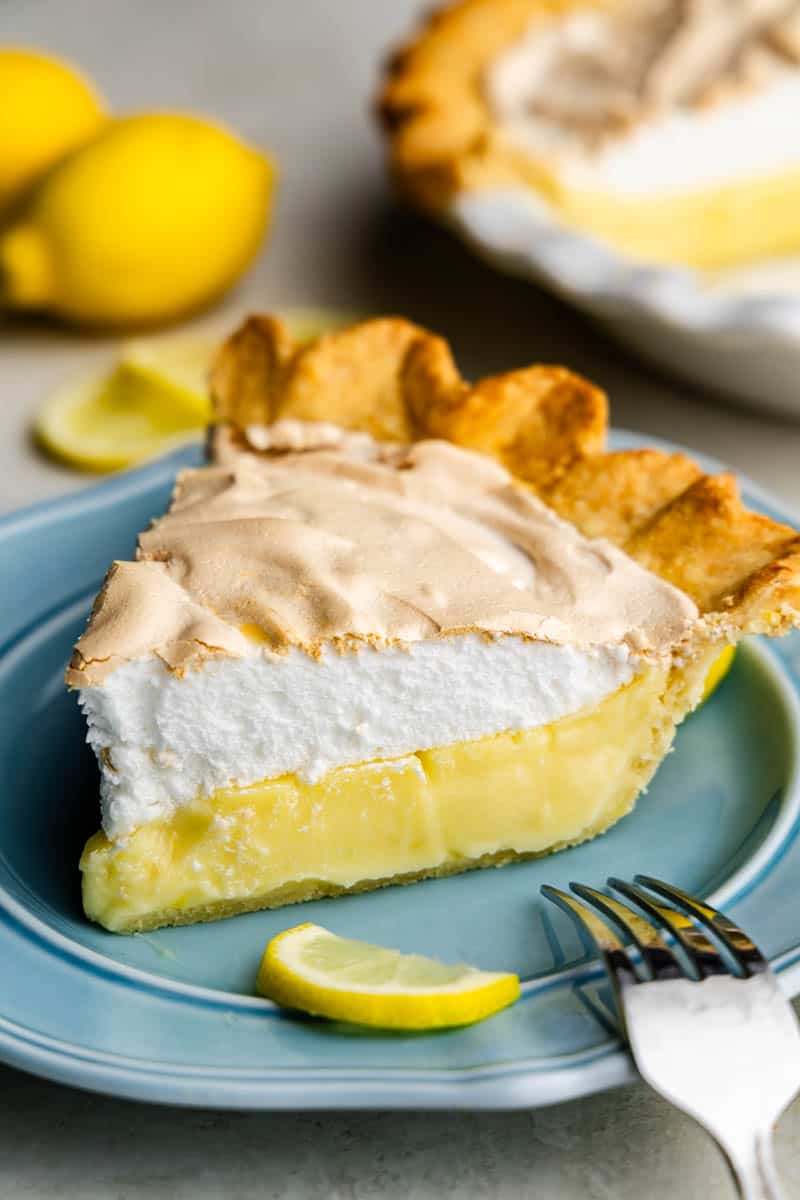 Slice of lemon meringue pie on blue plate