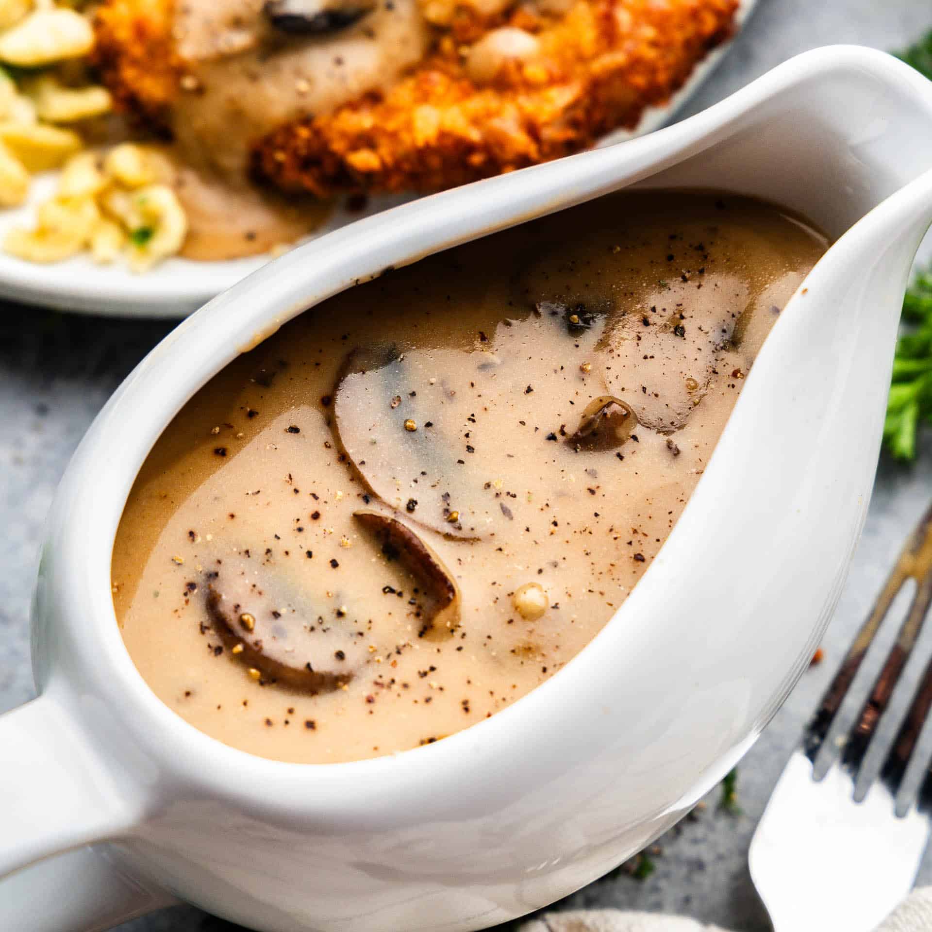 An overhead view of a gravy boat filled with mushroom gravy.