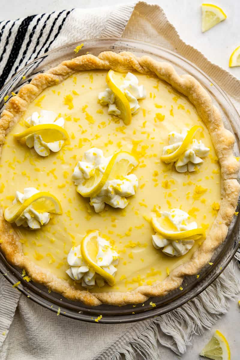 A close up overhead view of an unsliced old fashioned creamy lemon pie.