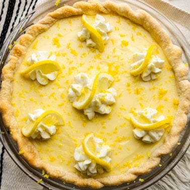 An overhead shot of a creamy lemon pie set next to a pie server spatula.