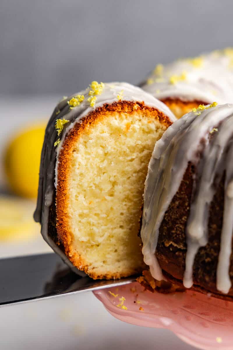 A close up view of a slice of lemon poundcake being removed from the cake.