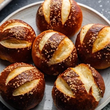 An overhead view of a plate of homemade pretzel rolls.