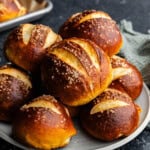 A plate piled high with homemade pretzel rolls.