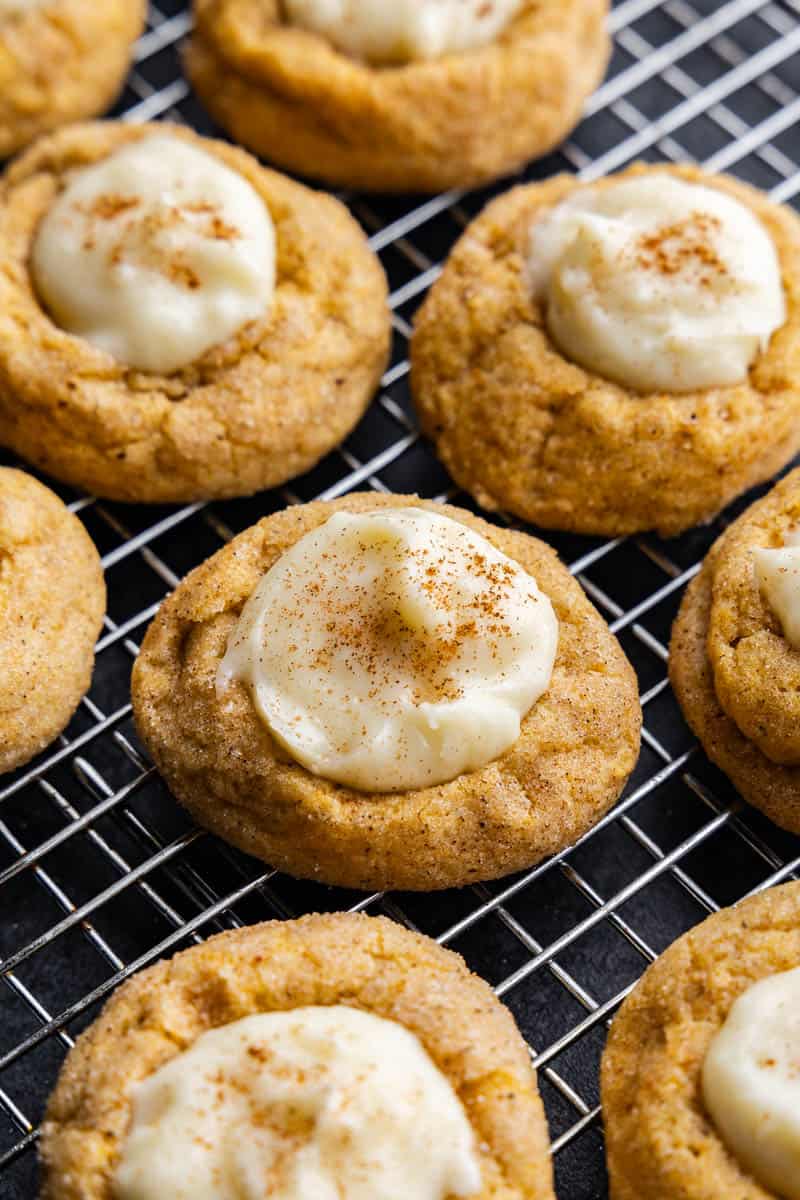 A closer view of Pumpkin Cheesecake Thumbprint Cookies on a wire cooling rack.