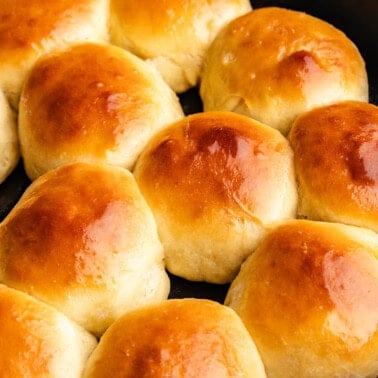 A cast iron skillet filled with golden brown rolls.