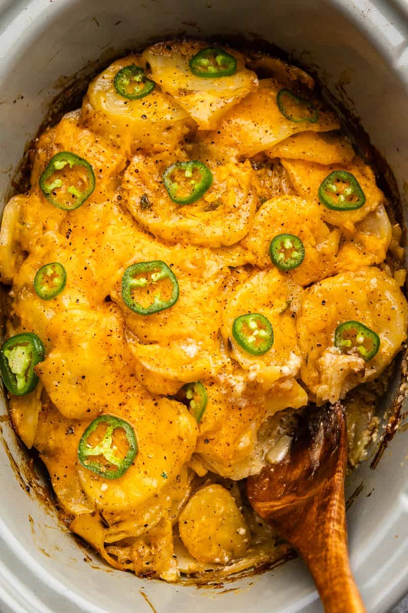 An overhead view looking down on a slow cooker of jalapeño scalloped potatoes.