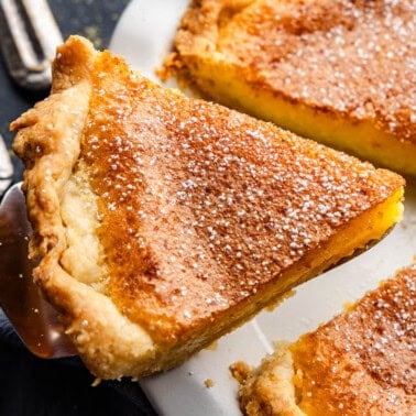 A slice of chess pie being lifted out of the pan by a pie server.