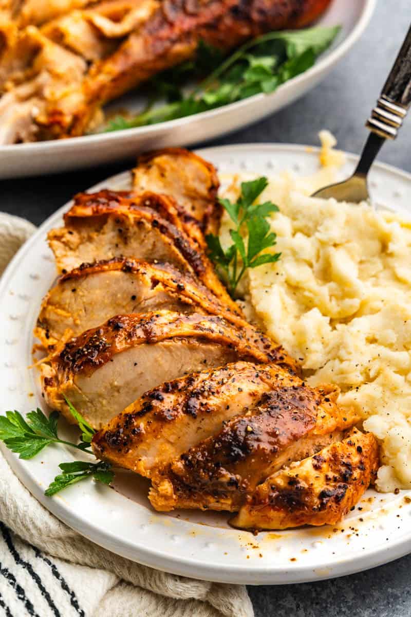 Slices of spatchcock turkey on a plate with mashed potatoes