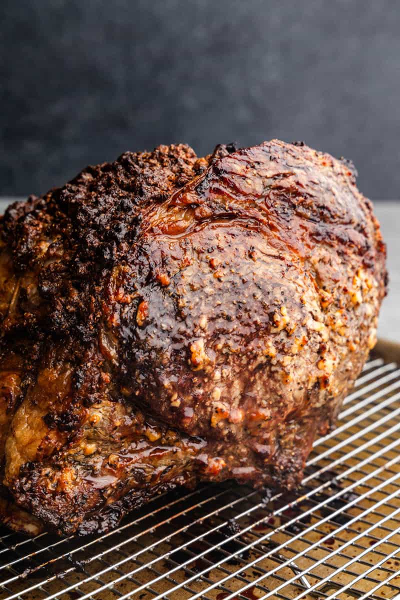 A whole, sliced ​​horseradish crusted prime rib on a wire rack.