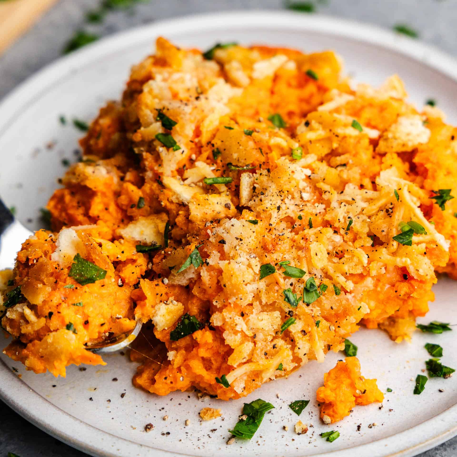 A plate holding a serving of cheesy carrot casserole.