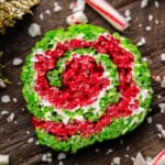 A close up view of a red, white, and green Christmas rice krispie treat with peppermint candy cane.