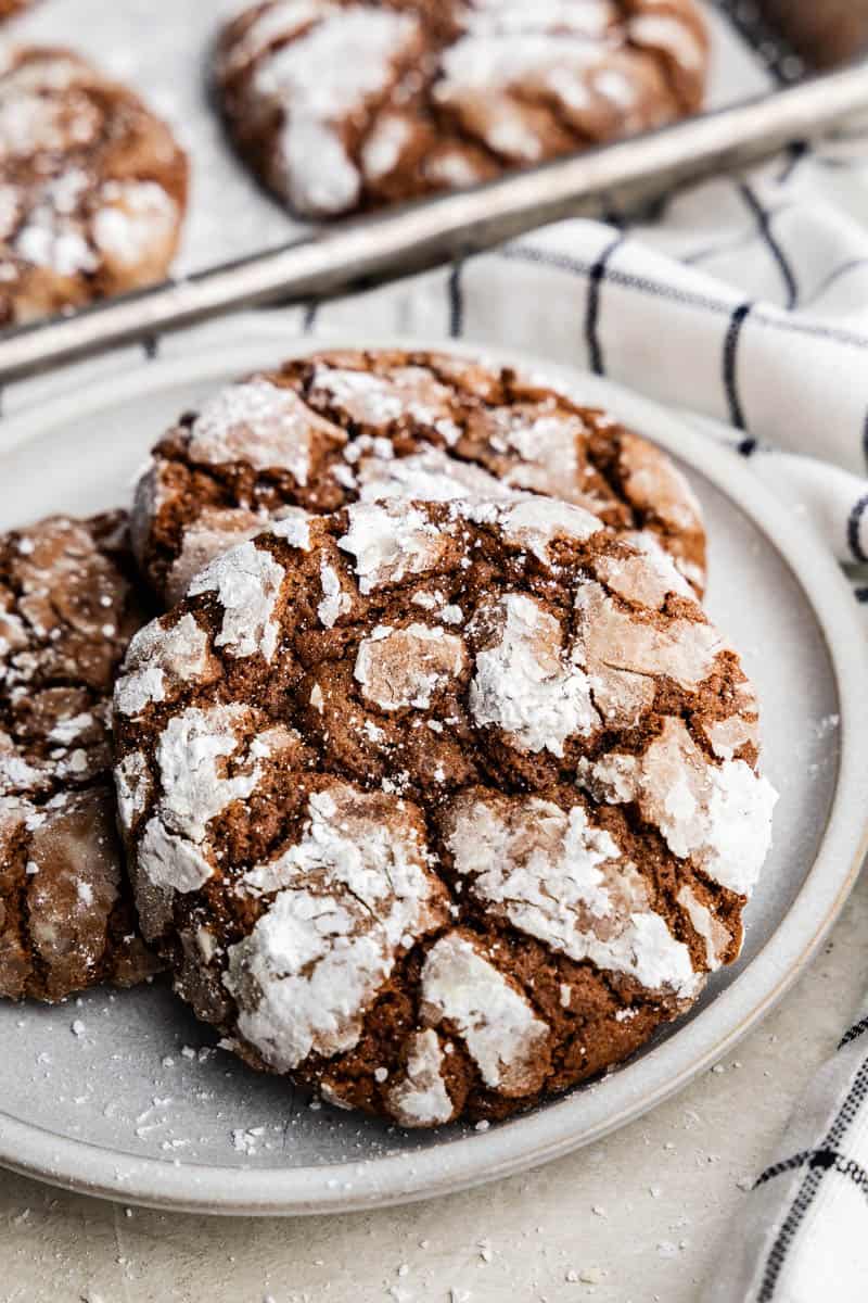 A close up of several chocolate crinkle cookies on a plate.