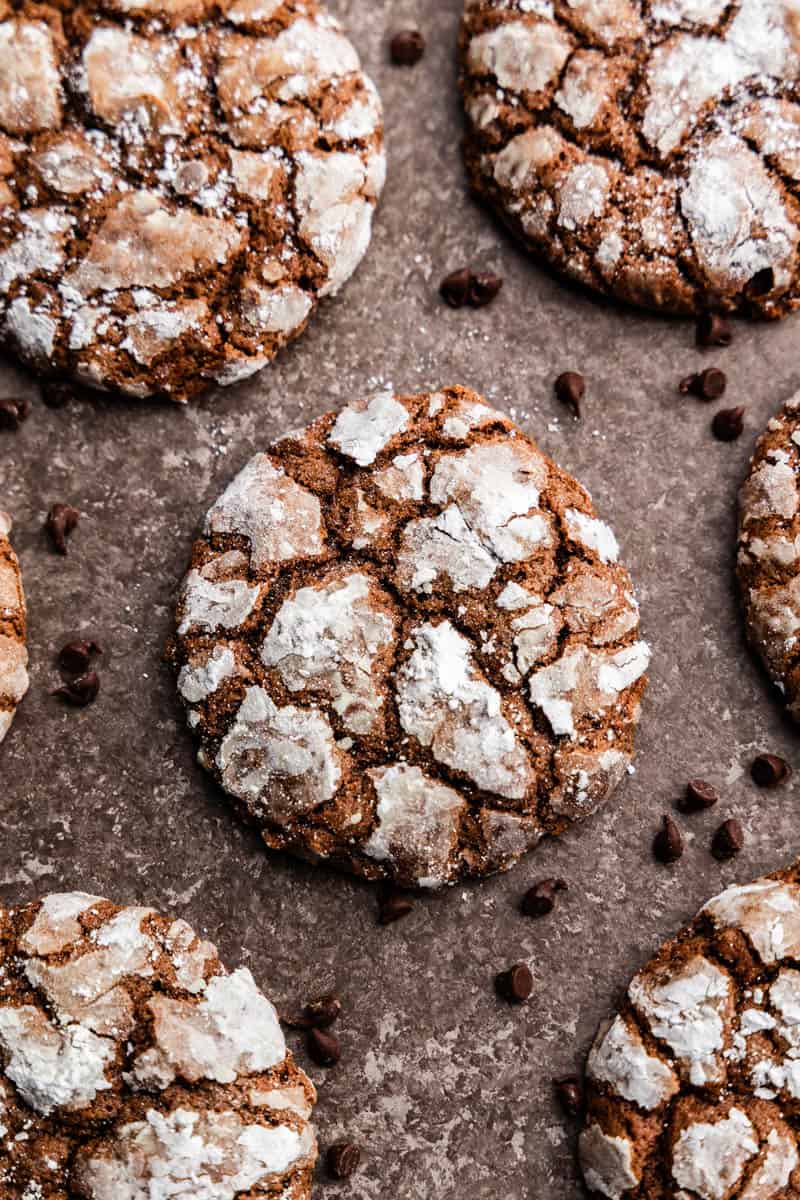 A top view close up of chocolate crinkle cookies, focused on the middle cookie.