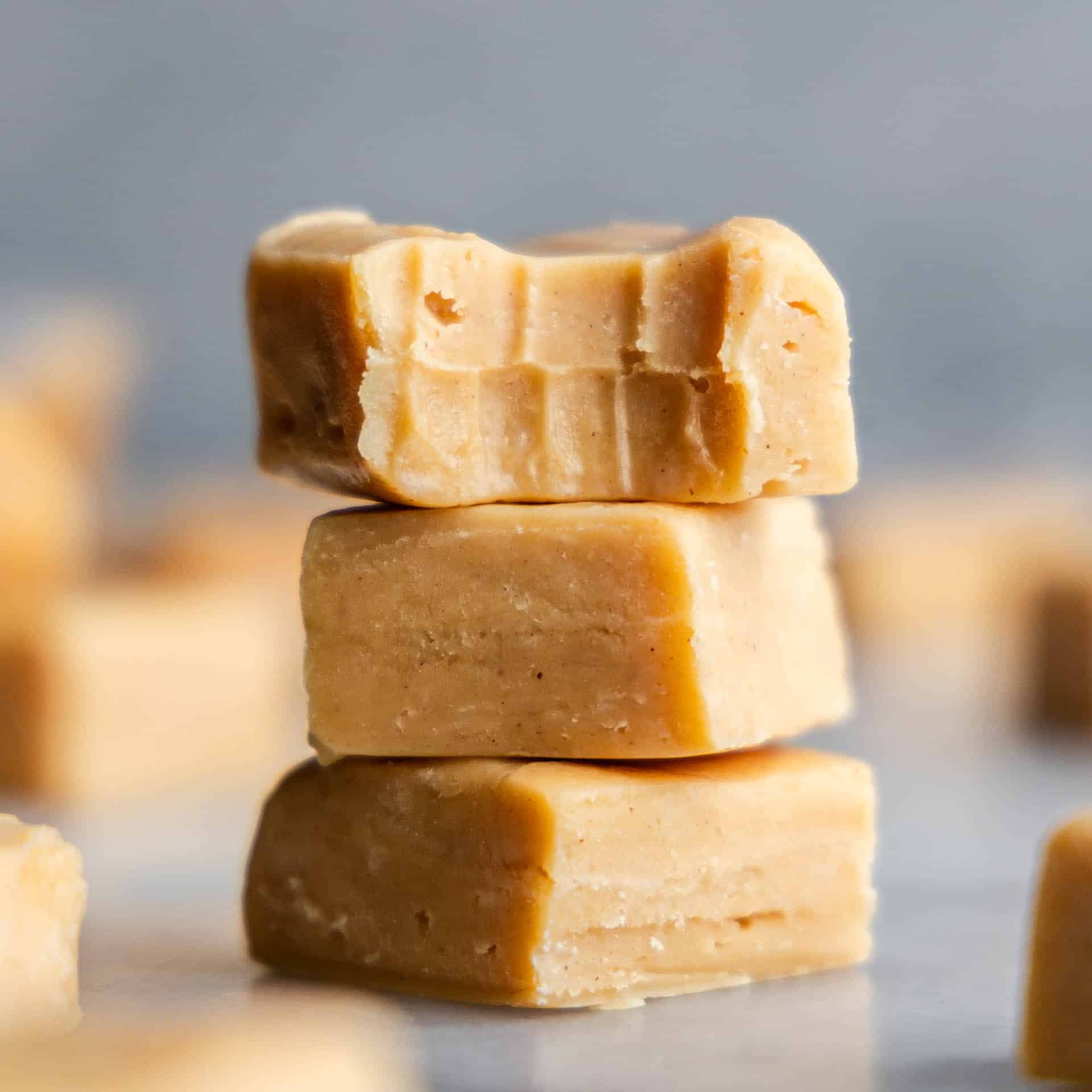 peanut butter fudge stacked with one piece with bite taken out of it