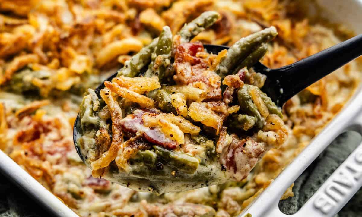 A close up view of a pan of green bean casserole topped with crispy onions.