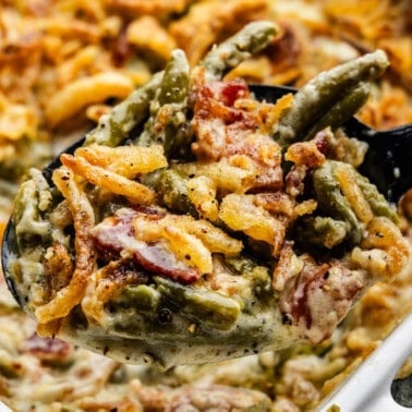 A close up view of a pan of green bean casserole topped with crispy onions.