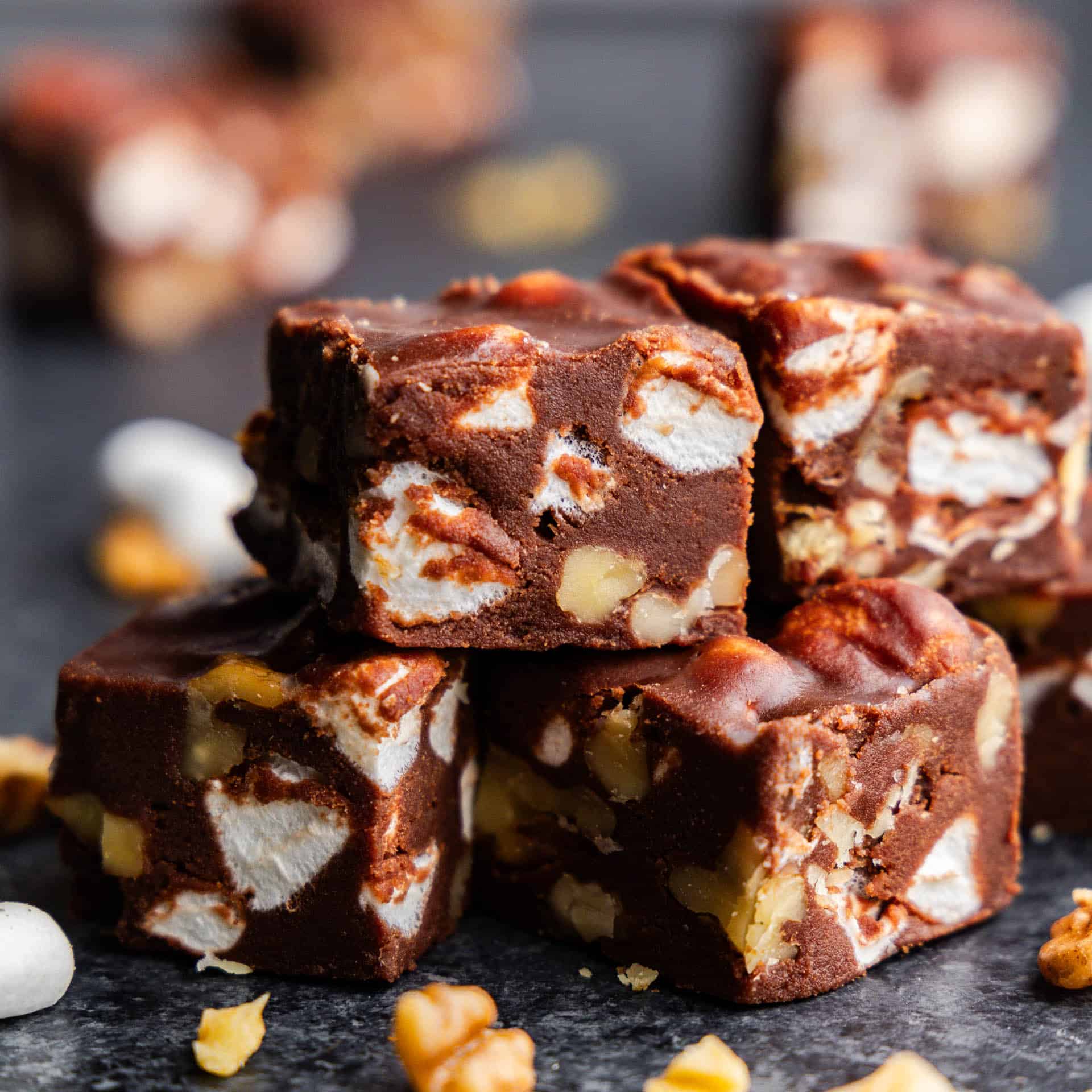 A close up view of a stack of fantasy fudge with marshmallow and chopped walnuts.