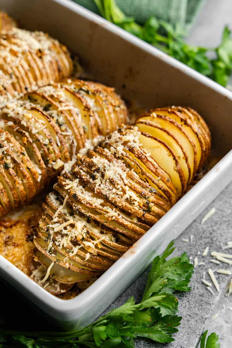 Golden baked hasselback potatoes in a casserole dish fresh from the oven.