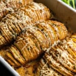 A casserole dish filled with perfectly baked hasselback potatoes ready to serve.